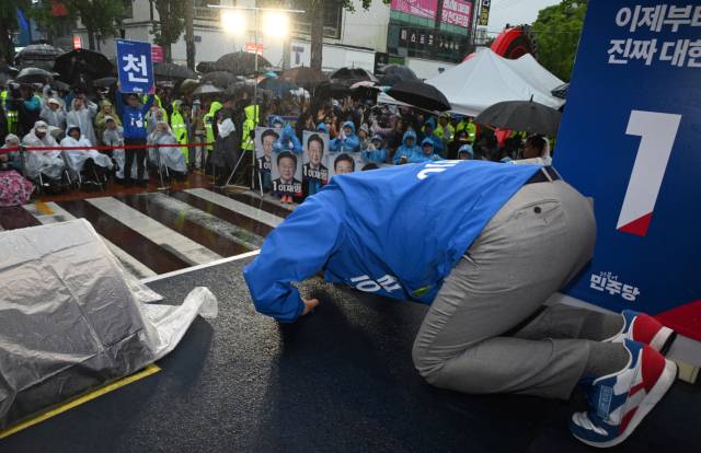 이재명 더불어민주당 대선 후보가 15일 쏟아지는 비에도 불구하고 수많은 인파가 운집한 전남 순천시 연향동 패션의거리에서 유세를 마친 뒤 빗속에서 본인의 연설을 들어준 지지자들을 향해 큰절하고 있다. 순천=오승현 기자