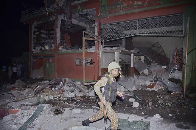 지난 5월 7일 파키스탄령 카슈미르의 주도 무자파라바드 인근에서 파키스탄 군인이 인도의 미사일 공격으로 무너진 건물을 지나가고 있다.  AP연합뉴스