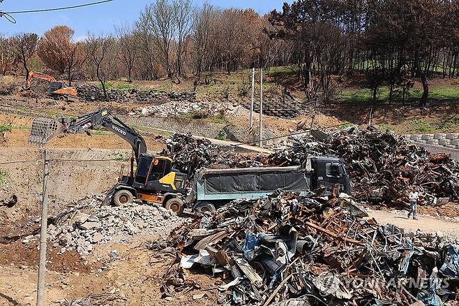 불탄 집 철거 (영덕=연합뉴스) 손대성 기자 = 7일 경북 영덕군 영덕읍 석리의 산불 피해지역에서 중장비 작업자들이 폐기물을 치우고 있다. 2025.5.7 sds123@yna.co.kr