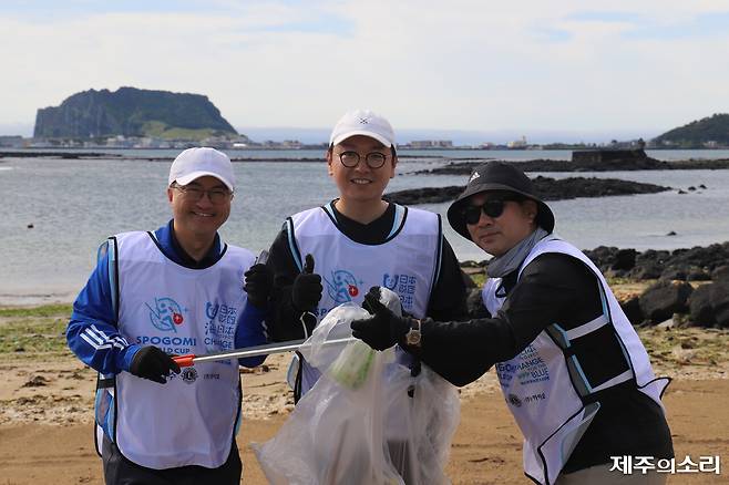 해안가 쓰레기를 수거 중인 참가자들이 즐거운 표정으로 대회에 참여하고 있다. ⓒ제주의소리