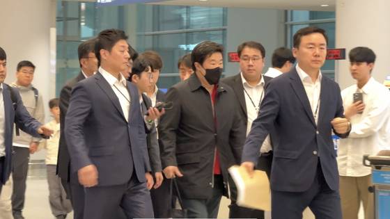 17일 오후 인천공항에서 김병주 MBK파트너스 회장이 귀국 뒤 검찰과 함께 이동하고 있다. 〈사진=JTBC〉