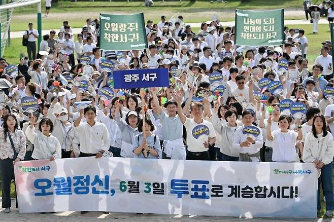 광주 서구청 공무원과 주민들이 ‘오월정신, 6월 3일 투표로 계승합시다’라는 문구가 적힌 현수막과 손팻말을 들고 있다. 서구 제공