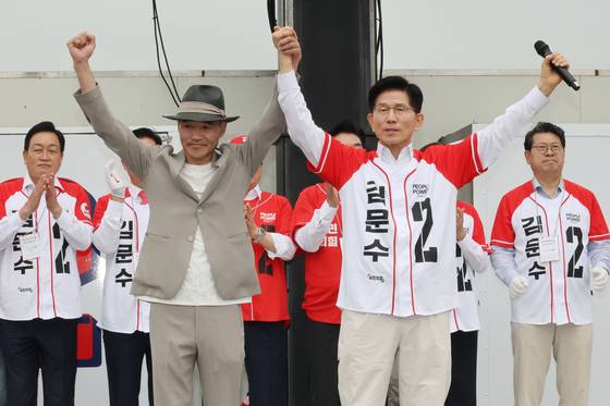 김문수 국민의힘 대선후보가 16일 수원 지동시장에서 2020년 북한군에 의해 피살된 공무원 유족 이래진씨의 손을 잡고 인사하고 있다. [뉴시스]