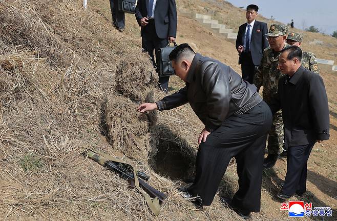 지난달 4일 김정은 위원장이 길리슈트를 입은 북한군 병사를 신기한 듯 살펴보고 있다.