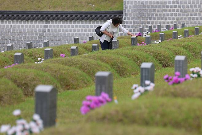 15일 광주 국립 5·18 민주묘지를 찾은 참배객이 이요승씨의 묘비를 쓰다듬고 있다.