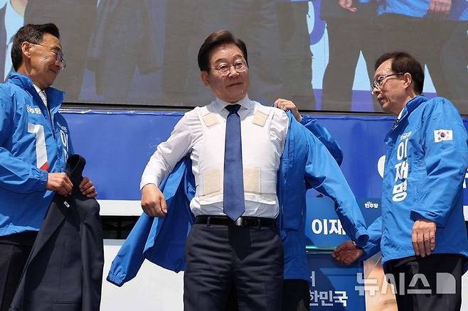 [서울=뉴시스] 조성우 기자 = 이재명 더불어민주당 대선후보가 제21대 대통령선거 공식 선거운동이 시작된 12일 오전 서울 종로구 청계광장에서 열린 중앙선거대책위원회 출정식에서 선거운동복을 입고 있다. 2025.05.12. xconfind@newsis.com