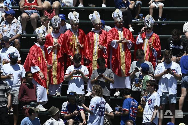 [시카고=AP/뉴시스] 시카고 화이트삭스 팬들이 17일(한국 시간) 미국 일리노이주 시카고의 리글리 필드에서 열린 2025 메이저리그(MLB) 시카고 컵스와의 경기에서 교황 복장을 한 채 응원전을 펼치고 있다. 2025.05.17