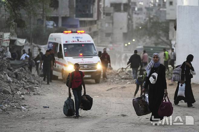 [가자시티=AP/뉴시스] 14일(현지 시간) 이스라엘군이 가자지구 가자시티 리말 지역의 학교와 병원 등지에 대피령을 내린 가운데, 팔레스타인 주민들이 대피하고 있다. 2025.05.15