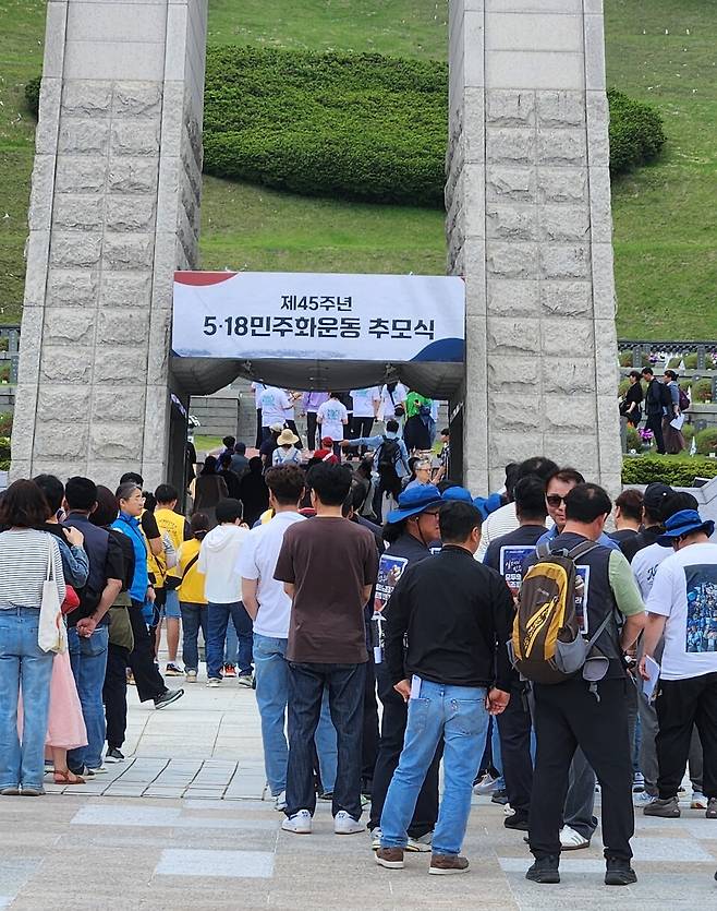 ​5·18민주화운동 제45주년을 하루 앞두고 추모 열기가 최고조에 달했다. 17일 오전 광주 북구 운정동 국립 5·18 민주묘지. 전국 각지에서 찾아온 참배객들로 북새통을 이뤘다. 이날 오전부터 내린 비로 묘지 전역의 땅이 젖어 있었지만, 백발의 어르신부터 앳된 꼬마까지 참배객들은 아랑곳 않고 추모탑 앞에서 묵념하고 헌화했다. 화창한 날씨의 오후가 되자 참배객들은 기하급수적으로 늘어나 인산인해를 이뤘다. 참배객들이 헌화, 분향하기 위해 추모탑 앞에 줄서 있다. ⓒ시사저널 정성환​