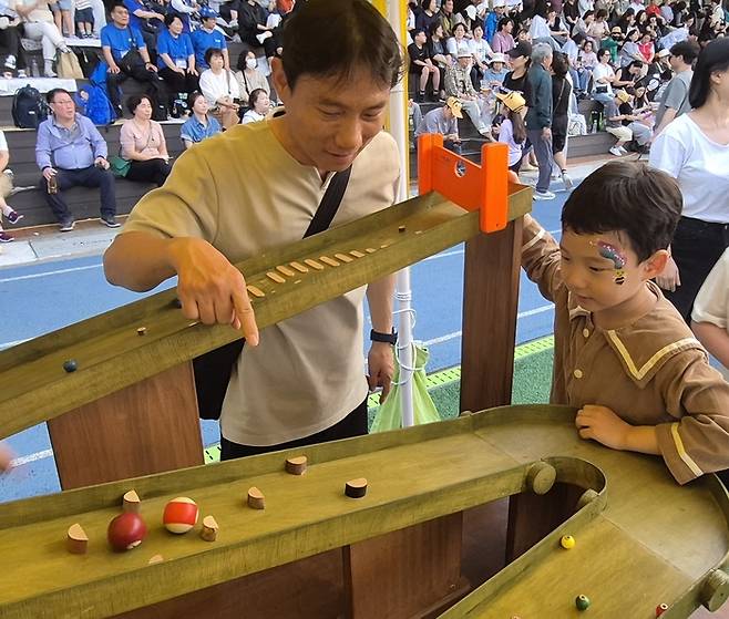 17일 2025 대구 앞산축제 현장에 마련된 앞산 나무 오락실에서 배재억(44) 씨와 아들 윤후(7) 군이 게임을 즐기고 있다. 조윤화 기자