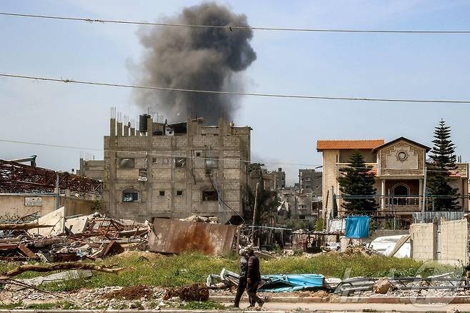 25일(현지시간) 팔레스타인 가자 지구의 누세이라트 난민 캠프에서 이스라엘 군의 포격을 받은 건물서 연기 기둥이 솟아 오르고 있다. 2025.03.26 ⓒ AFP=뉴스1 ⓒ News1 우동명 기자