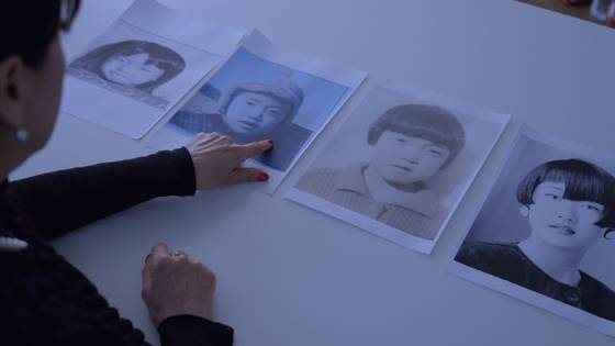 다큐멘터리 '케이 넘버'에서 해외 입양인 미오카 밀러(김미옥)가 자신의 어린 시절 사진을 보고 있다. 사진 마노엔터테인먼트