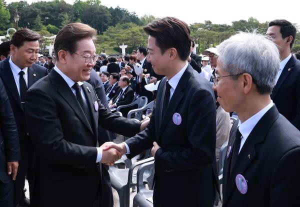 ▲2025년 5월 18일 광주광역시 북구 국립 5·18민주묘지에서 열린 5·18민주화운동 45주년 기념식에 참석한 더불어민주당 이재명, 개혁신당 이준석, 민주노동당 권영국 대선 후보(왼쪽부터). 사진상 권 후보 왼편에서 이재명 후보와 이준석 후보가 악수하며 인사를 나누고 있다. ⓒ연합뉴스