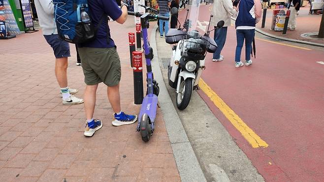 17일 전국 최초 ‘킥보드 없는 거리’로 운영되는 홍대 레드로드에 주차된 킥보드와 오토바이. 안병준 기자