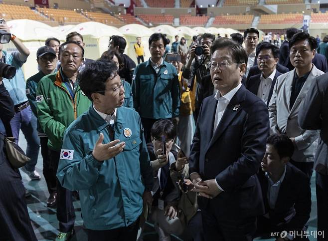 [광주=뉴시스] 조성우 기자 = 이재명 더불어민주당 대선후보가 17일 광주 광산구 광주여자대학교 유니버시아드 체육관에 마련된 금호타이어 공장 화재 대피소를 찾아 박병규 광산구청장의 현황 설명을 듣고 있다. (공동취재) 2025.05.17. photo@newsis.com /사진=