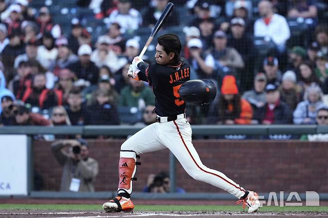 [샌프란시스코=AP/뉴시스] 샌프란시스코 자이언츠의 이정후가 17일(현지 시간) 미 캘리포니아주 샌프란시스코의 오라클 파크에서 열린 2025 메이저리그 애슬레틱스와의 경기 1회말 배트를 휘두르다 헬멧이 벗겨지고 있다. 2025.05.18.