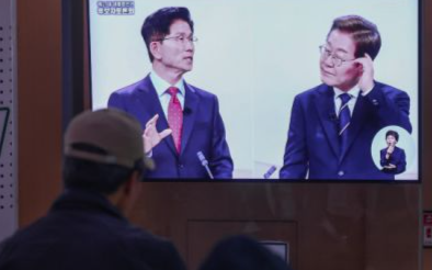 지난 18일 서울역 대합실에서 시민들이 제21대 대선 1차 후보자 토론회 중계방송을 지켜보고 있다. 연합뉴스
