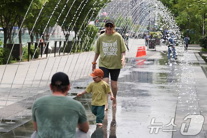 서울 낮 최고 기온 26도 등 초여름 날씨을 보인 14일 서울 광화문광장 분수터널에서 외국인 관광객들이 더위를 식히고 있다. 2025.5.14/뉴스1 ⓒ News1 허경 기자