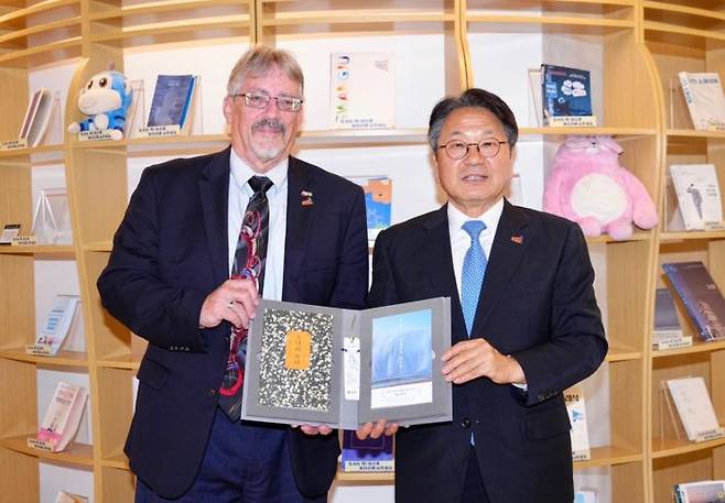 강기정 광주시장이 지난 18일 오후 전일빌딩245에서 5·18민주화운동 당시 시민군으로 참여한 미국인 데이비드 돌린저씨와 환담을 가진 뒤, 한강 작가 도서를 선물하고 있다. 광주시 제공