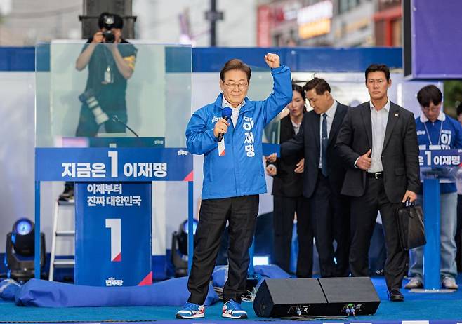 이재명 더불어민주당 후보의 유세가 열리는 19일 오후 서울 마포구 상상마당 앞에서 지지자들에게 인사를 하고 있다. 후보 뒷편에는 삼면이 보호된 방탄유리가 설치되어 있다. 사진공동취재단