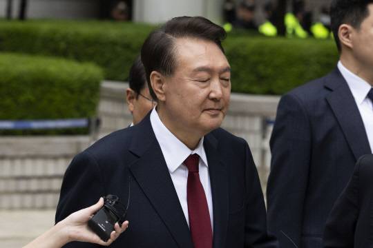 윤석열 전 대통령이 19일 서울 서초구 서울중앙지방법원에서 열린 내란 우두머리 혐의, 직권남용 권리행사방해 혐의 사건 4차 오전 공판을 마친 후 취재진의 질문을 받으며 이동하고 있다. [사진공동취재단=연합뉴스]