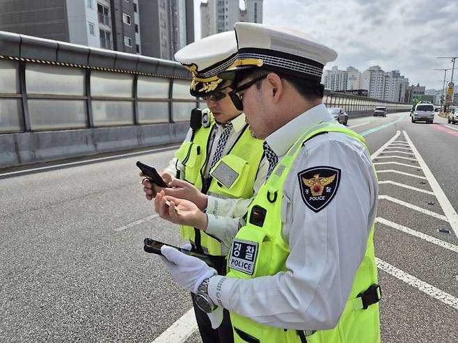 내부순환로 성수 방면 북부간선로 분기점에서 운전 중 휴대전화를 사용한 운전자에게 '교통 위반 딱지'를 부과하는 모습. 사진=공동취재단