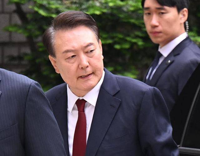 윤석열(왼쪽) 전 대통령이 19일 서울 서초구 중앙지법에서 열린 내란수괴 및 직권남용 권리행사방해 혐의 사건 4차 공판에 출석하고 있다. 뉴스1