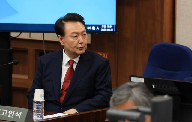 12·3 불법계엄을 선포해 내란 우두머리 혐의 등으로 재판에 넘겨진 윤석열 전 대통령이 4월 21일 서울 서초구 서울중앙지법 417호 법정에 앉아 변호인단과 대화를 하고 있다. 뉴시스