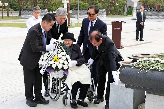 19일 노태우 전 대통령의 배우자인 김옥숙 여사가 아들 노재헌씨와 함께 광주 북구 운정동 국립5·18민주묘지를 찾아 헌화하고 있다. 국립5·18민주묘지 제공, 연합뉴스
