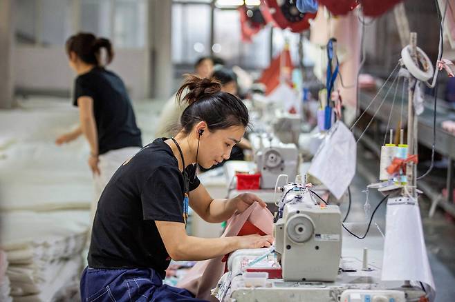 지난 15일(현지시간) 중국 동부 장쑤성 난퉁에 위치한 섬유 공장에서 직원들이 가정용 섬유를 생산하고 있다. [AFP]