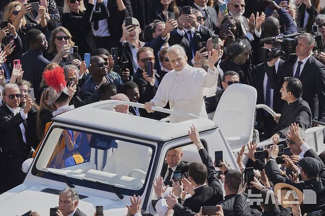 [바티칸=AP/뉴시스] 교황 레오 14세가 18일(현지 시간) 바티칸 성 베드로 광장에서 열린 즉위 미사에 무개차를 타고 이동하고 있다. 2025.05.19.