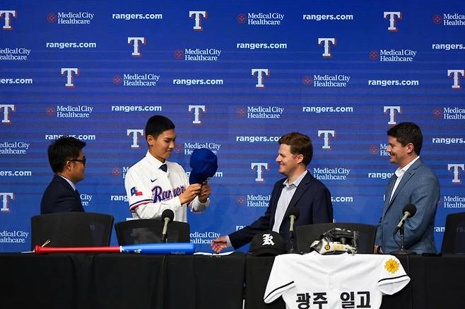 [서울=뉴시스] 광주일고 투수 겸 내야수 김성준이 18일(현지 시간) 미국 텍사스주 알링턴 글로브 라이프 파크에서 열린 텍사스 레인저스 입단식에서 모자를 쓰고 있다.김성준은 내년 고등학교 졸업 후 텍사스에 합류할 예정이다. (사진=리코스포츠에이전시 제공) 2025.05.19. photo@newsis.com *재판매 및 DB 금지