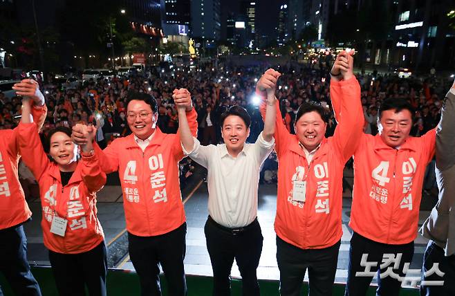 개혁신당 이준석 대선 후보가 12일 오후 서울 중구 청계광장에서 열린 출정식에서 선대위원장들과 두 팔을 들어올리며 시민들에게 인사하고 있다. 윤창원 기자