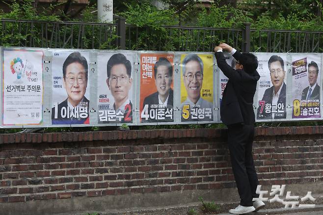 서울시선거관리위원회 관계자들이 15일 오전 서울 종로구 예술가의집 담장에 제21대 대통령선거 선거벽보를 부착하고 있다. 선거벽보는 이날부터 전국 8만2900여 곳에 첩부된다. 류영주 기자