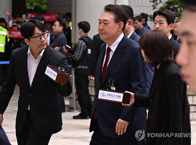 법정 향하는 윤석열 전 대통령 (서울=연합뉴스) 윤석열 전 대통령이 19일 서울 서초구 중앙지방법원에서 열린 내란 우두머리 혐의, 직권남용 권리행사방해 혐의 사건 4차 공판에 출석, 취재진의 질문을 받으며 이동하고 있다. 2025.5.19 [사진공동취재단] photo@yna.co.kr