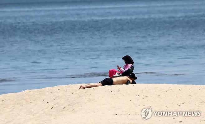 일광욕하기 좋은 여름 같은 해변 (강릉=연합뉴스) 유형재 기자 = 초여름 날씨가 이어진 19일 강원 강릉시 한 해변 백사장에서 관광객이 웃옷을 벗고 일광욕을 즐기고 있다. 2025.5.19 yoo21@yna.co.kr
