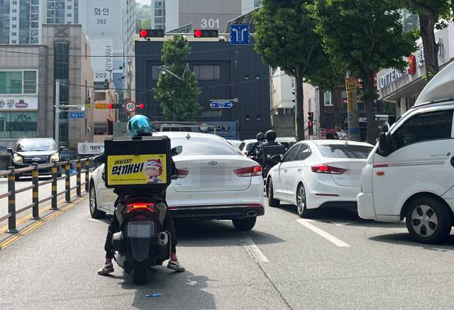경남 김해시 공공 배달앱 ‘먹깨비’ 스티커를 부착한 오토바이가 지난 11일 어방동 인제대 삼거리를 지나고 있다. 이경민 기자