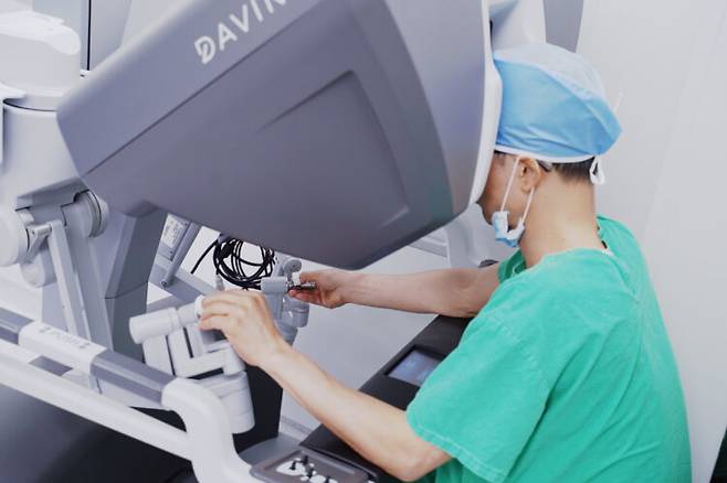 박성환 병원장(산부인과)이 다빈치 SP로봇의 '서전 콘솔'(Surgeon Console)을 조작해 부인과 질환 수술을 하고 있다. [사진=춘해병원]