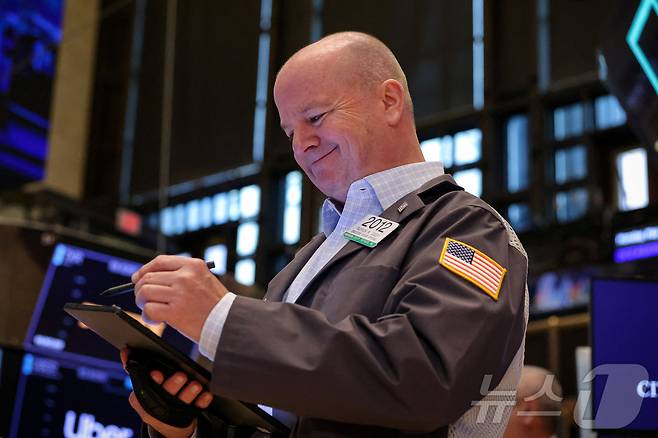 미증시 상승에 웃고 있는 NYSE의 한 트레이더. ⓒ 로이터=뉴스1