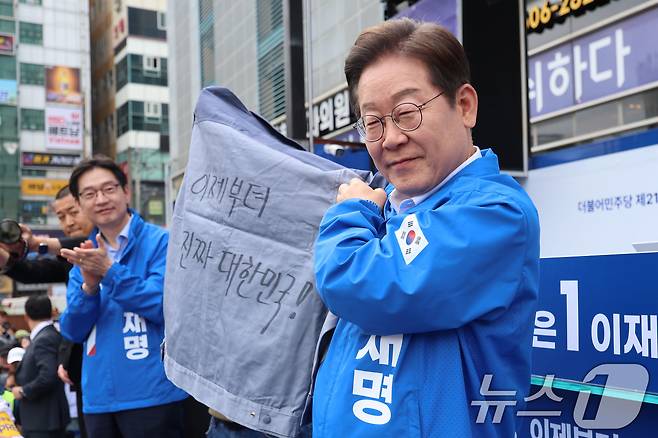 이재명 더불어민주당 대통령 후보가 민주당 험지로 꼽히는 부산·경남(PK) 지역 유세에 나선 14일 경남 창원시 상남분수광장에서 열린 집중유세에서 송순호 경남도당위원장으로부터 '이제부터 진짜 대한민국!' 문구가 써진 작업복을 전달 받고 있다. (공동취재) 2025.5.14/뉴스1 ⓒ News1 안은나 기자