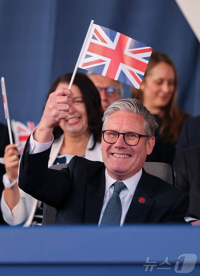 키어 스타머 영국 총리가 8일(현지시간) 런던에서 열린 2차 세계대전 승전 기념 행사에 참석해 영국 국기를 흔들고 있다. 2025.05.08. ⓒ AFP=뉴스1 ⓒ News1 이지예 객원기자
