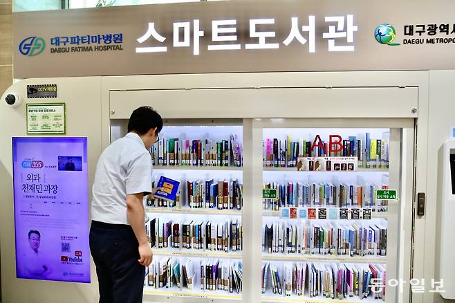 19일 대구 동구 대구파티마병원 동관 1층 스마트도서관에서 병원 이용객이 책을 빌리고 있다. 대구파티마병원 제공