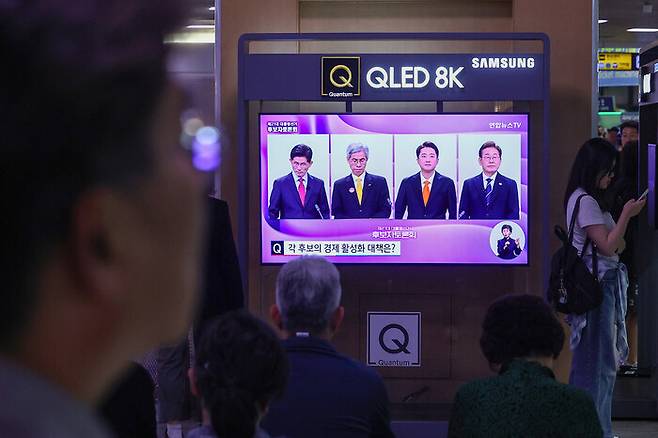 지난 18일 서울역 대합실에서 시민들이 제21대 대선 1차 후보자 토론회 중계방송을 지켜보고 있다. 연합뉴스