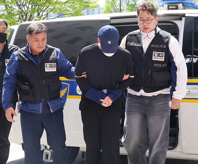 청주의 한 고등학교 내외부에서 흉기 난동을 벌여 교직원·시민 등 6명을 다치게 한 ㄱ 군(왼쪽 셋째 모자 쓴 이)이 30일 오후 영장실질심사를 받으려고 청주지법에 들어서고 있다. 연합뉴스