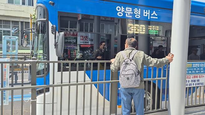 섬식정류장에서 시내버스 창문을 통해 버스기사에게 방향을 물어보는 승객. 서보미 기자