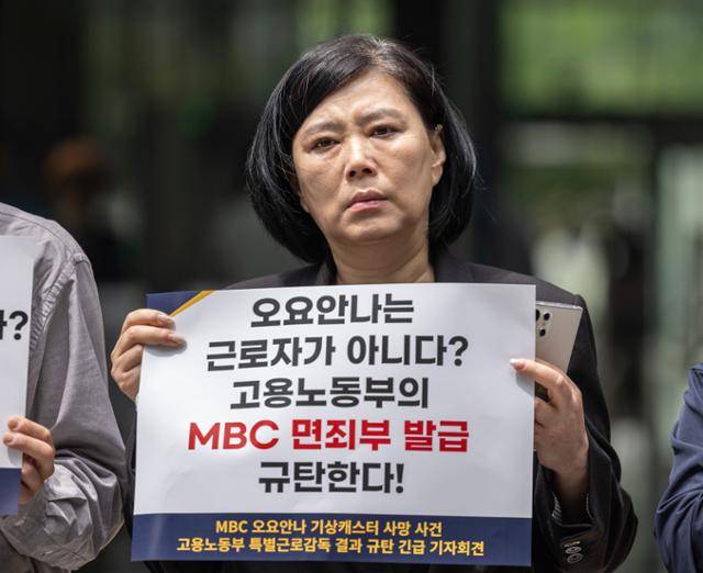19일 서울 중구 서울고용노동청 앞에서 MBC 기상캐스터였던 고(故) 오요안나씨의 어머니가 고용노동부 근로감독 결과를 규탄하는 손팻말을 들고 있다. 연합뉴스