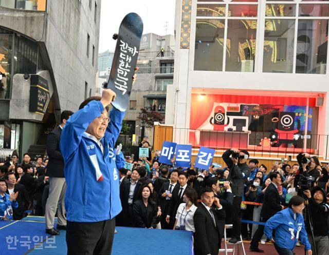 이재명 더불어민주당 대선 후보가 19일 서울 마포구 KT&G 상상마당 앞에서 유세를 하며 선물 받은 스케이드보드를 들고 있다. 고영권 기자