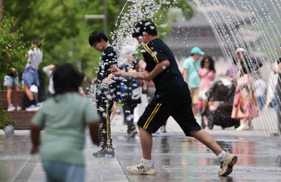 초여름 날씨가 나타난 지난 14일 서울 광화문광장 분수터널에서 시민들이 더위를 식히고 있다. 뉴스1