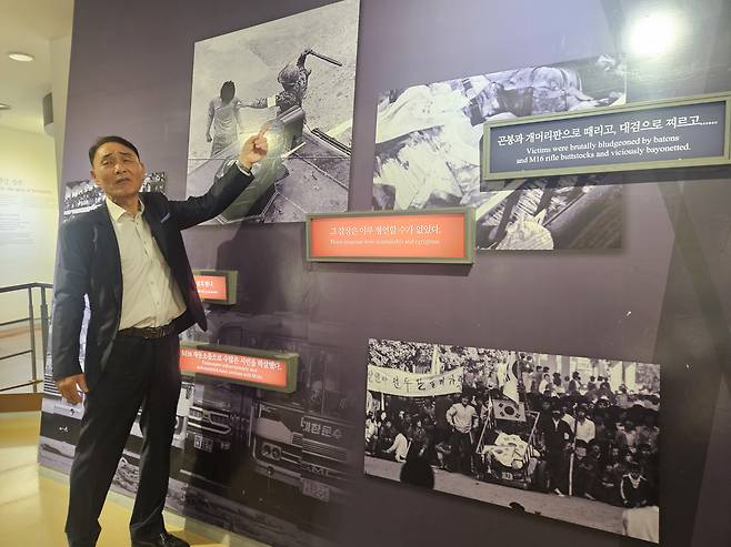김용철  5·18기념재단 오월지기가 5·18민주화운동기록관에 전시된 사진을 바라보며 그날의 참상을 설명하는 모습.