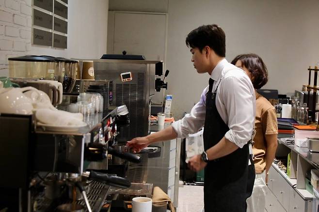 김용태 국민의힘 비상대책위원장이 19일 오후 서울 서초구 한 카페에서 커피를 내리며 카페 사장과 대화를 하고 있다.  [김용태 페이스북 캡처]